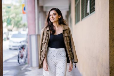 Gün boyunca bir geçit Asya'da bir şehirde yürürken bir uzun boylu, güzel, ince ve zarif Hint Asyalı kadın portresi. O zarif giyindi ve bir ceket omuzları üzerinde bol dökümlü vardır.