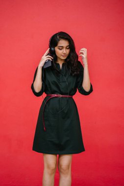 Bir güzel, Genç ve çekici Hint Asyalı kadın bir yeşil elbise ve kırmızı bir arka plan kırmızı kemer Studio portresi