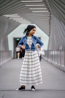 Gün boyunca güzel bir köprüde tek başına duran uzun boylu, genç, zarif ve çekici Malezyalı Müslüman bir kadının portresi..