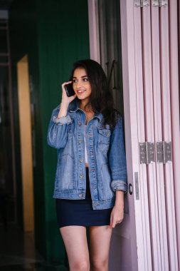 Onun Smartphone'da bahseden bir güzel, uzun boylu, zarif ve genç Hintli Asyalı kadın portresi. O bir retro Kot ceket giyiyor 