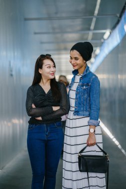 Gündüz vakti köprüde farklı etnik kökenlere sahip iki arkadaş. Biri Malezyalı Müslüman bir kadın, diğeri de Çinli bir Asyalı. İkisi de genç, enerjik ve çekici..