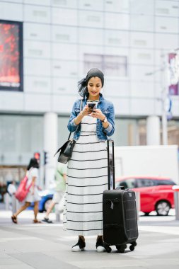 Genç, uzun, ince ve zarif bir Malezyalı Müslüman 'ın portresi şehrin kalabalık bir caddesinde duruyor..