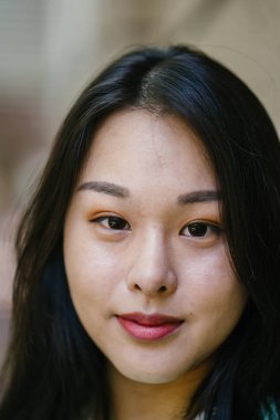 Gündüz vakti genç, seksi ve çekici bir Asyalı kadının portresi. O nane yeşili bir kazak giyiyor.