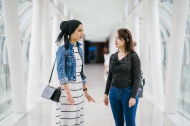 Gündüz vakti köprüde farklı etnik kökenlere sahip iki arkadaş. Biri Malezyalı Müslüman bir kadın, diğeri de Çinli bir Asyalı. İkisi de genç, enerjik ve çekici..