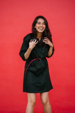 Bir güzel, Genç ve çekici Hint Asyalı kadın bir yeşil elbise ve kırmızı bir arka plan kırmızı kemer Studio portresi