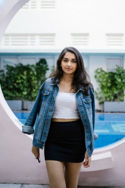 Bir güzel, genç ve çekici Hint Asyalı kadın beyaz bluz, mavi etek ve denim ceket portresi.