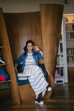 Genç, zarif ve çekici Malezyalı Müslüman kadın gün boyunca elbise ve kot ceket giyiyor..