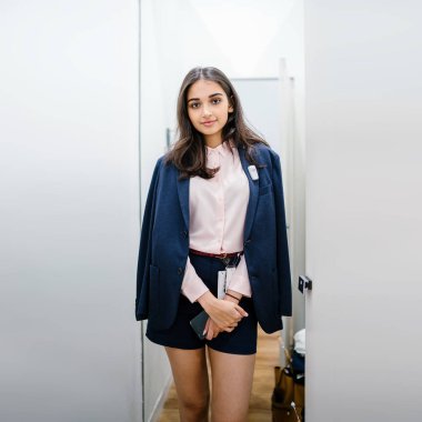 Yeni giyim moda salonu bir alışveriş merkezinde bir montaj odasında çalışıyor bir genç ve güzel Hint Asyalı kadın portresi.