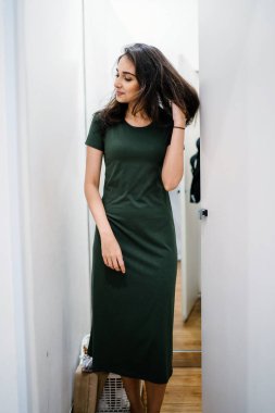 Yeni giyim moda salonu bir alışveriş merkezinde bir montaj odasında çalışıyor bir genç ve güzel Hint Asyalı kadın portresi.