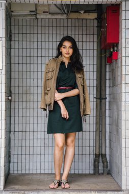 Hint Asyalı kadın Genç, uzun boylu, ince ve zarif bir portre için poz veriyor. O rahat ve şık rahat giysiler giyiyor ve bir adamın ceketi omuzları üzerinde bol dökümlü vardır. 