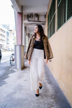 Gün boyunca bir geçit Asya'da bir şehirde yürürken bir uzun boylu, güzel, ince ve zarif Hint Asyalı kadın portresi. O zarif giyindi ve bir ceket omuzları üzerinde bol dökümlü vardır.