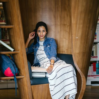 Genç, uzun boylu, zayıf, çekici ve güzel Malezyalı Müslüman kadın kütüphanede oturmuş kitap okuyor. Çalışıyor ve tek başına araştırma yapıyor..