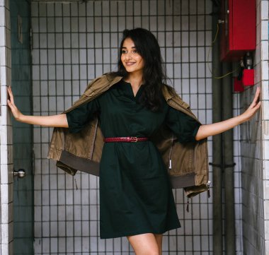 Hint Asyalı kadın Genç, uzun boylu, ince ve zarif bir portre için poz veriyor. O rahat ve şık rahat giysiler giyiyor ve bir adamın ceketi omuzları üzerinde bol dökümlü vardır. 