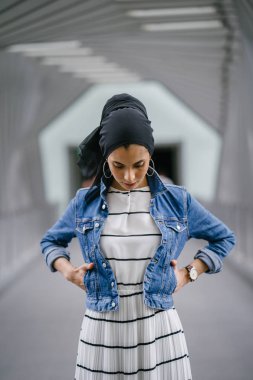 Genç, zarif ve çekici Malezyalı Müslüman kadın gün boyunca elbise ve kot ceket giyiyor..