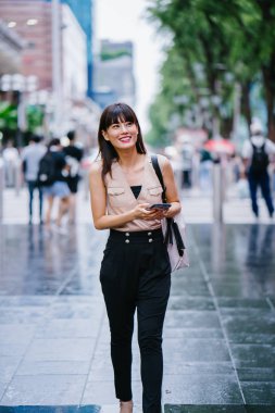 Onun smartphone kullanarak Genç, çekici Çinli Asyalı kadın