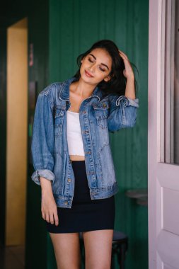 gün boyunca şehrin sokakta yürürken uzun boylu, genç ve zarif Hint Asyalı bir kadın. O bir retro Kot ceket giyiyor