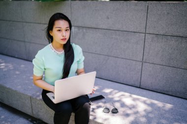 Genç ve çekici bir Asyalı kadın öğrenci oturur ve gün boyunca bir üniversite kampüsünde onu dizüstü bilgisayar üzerinde çalışır. O, o çalışırken gelişigüzel giyinmiş. 