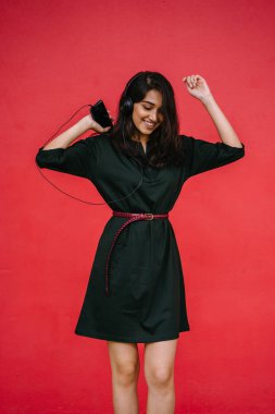 Bir güzel, Genç ve çekici Hint Asyalı kadın bir yeşil elbise ve kırmızı bir arka plan kırmızı kemer Studio portresi