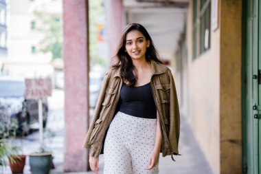 Gün boyunca bir geçit Asya'da bir şehirde yürürken bir uzun boylu, güzel, ince ve zarif Hint Asyalı kadın portresi. O zarif giyindi ve bir ceket omuzları üzerinde bol dökümlü vardır.