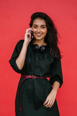 Bir güzel, Genç ve çekici Hint Asyalı kadın bir yeşil elbise ve kırmızı bir arka plan kırmızı kemer Studio portresi