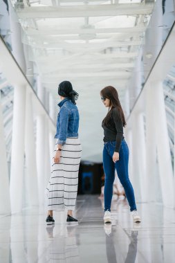 Farklı etnik kökenlere sahip iki arkadaş gün boyunca bir köprüde yan yana dururlar. Biri Malezyalı Müslüman bir kadın, diğeri de Çinli bir Asyalı. İkisi de genç, enerjik ve çekici..