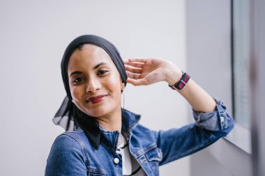 Genç, zarif ve çekici Malezyalı Müslüman kadın gün boyunca elbise ve kot ceket giyiyor..