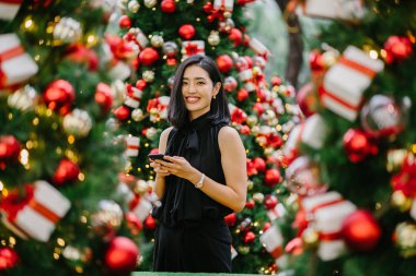 Güzel ve genç bir Kore Asya kadın portresi beholds ve harikası Noel süsleri smiling
