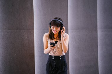 Onun kulaklık müzik dinlemek orta yaşlı, fotojenik bir Çinli kadın portresi