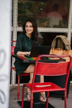 genç üniversite öğrencisi (Hint Asyalı kadın) eğitim ve gün boyunca dizüstü bilgisayar bir masa başında çalışma