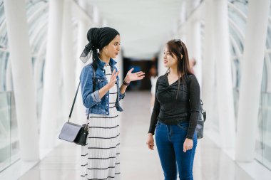 Gündüz vakti köprüde farklı etnik kökenlere sahip iki arkadaş. Biri Malezyalı Müslüman bir kadın, diğeri de Çinli bir Asyalı. İkisi de genç, enerjik ve çekici..