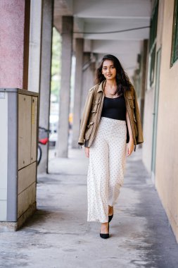 Gün boyunca bir geçit Asya'da bir şehirde yürürken bir uzun boylu, güzel, ince ve zarif Hint Asyalı kadın portresi. O zarif giyindi ve bir ceket omuzları üzerinde bol dökümlü vardır.