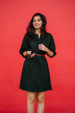 Bir güzel, Genç ve çekici Hint Asyalı kadın bir yeşil elbise ve kırmızı bir arka plan kırmızı kemer Studio portresi