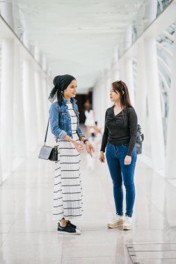 Gündüz vakti köprüde farklı etnik kökenlere sahip iki arkadaş. Biri Malezyalı Müslüman bir kadın, diğeri de Çinli bir Asyalı. İkisi de genç, enerjik ve çekici..