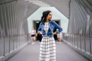 Gün boyunca güzel bir köprüde tek başına duran uzun boylu, genç, zarif ve çekici Malezyalı Müslüman bir kadının portresi..