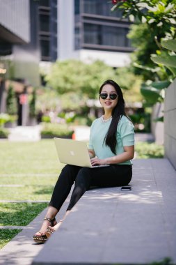 Genç ve çekici bir Asyalı kadın öğrenci oturur ve gün boyunca bir üniversite kampüsünde onu dizüstü bilgisayar üzerinde çalışır. O, o çalışırken gelişigüzel giyinmiş. 