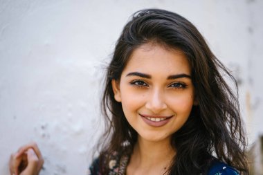 bir uzun boylu, Genç, zarif ve güzel Hint Asyalı kadın bir sokakta yıpranmış bir duvara portresi 