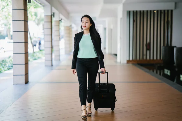 一位年轻的亚洲妇女正在拉她的手提箱行李 她迷人 穿着时尚 — 图库照片