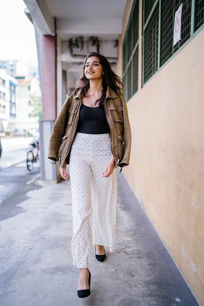 Gün boyunca bir geçit Asya'da bir şehirde yürürken bir uzun boylu, güzel, ince ve zarif Hint Asyalı kadın portresi. O zarif giyindi ve bir ceket omuzları üzerinde bol dökümlü vardır.