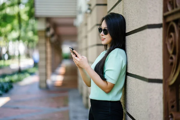 一个年轻美丽的拿着智能手机的亚裔妇女的画像 — 图库照片