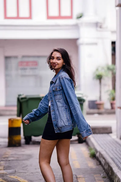 身材高大 优雅的印度亚裔妇女白天走在城市的一条小巷里 她穿着一件复古的粗斜纹棉布夹克 — 图库照片