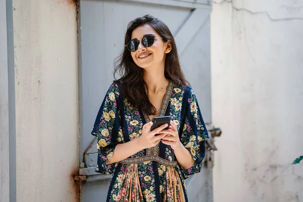 여자의 초상화는 매력적이 아시아 드레스와 그녀의 스마트폰으로 선글라스 — 스톡 사진