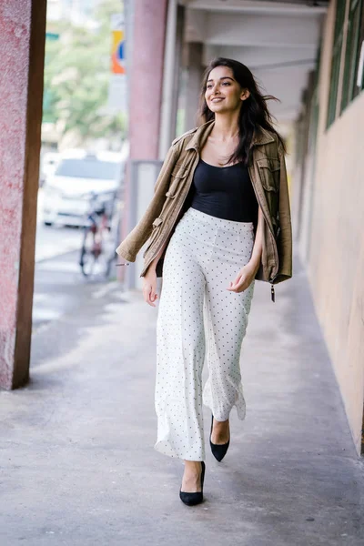 Gün boyunca bir geçit Asya'da bir şehirde yürürken bir uzun boylu, güzel, ince ve zarif Hint Asyalı kadın portresi. O zarif giyindi ve bir ceket omuzları üzerinde bol dökümlü vardır.