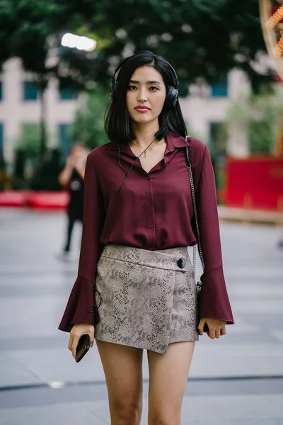 美丽的韩国女人穿着一件优雅的衬衫和短裤跳舞 她走在城市的街道上 戴着耳机 — 图库照片