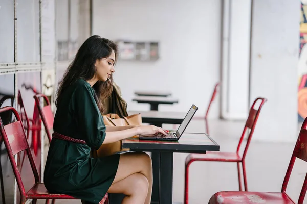 genç üniversite öğrencisi (Hint Asyalı kadın) eğitim ve gün boyunca dizüstü bilgisayar bir masa başında çalışma