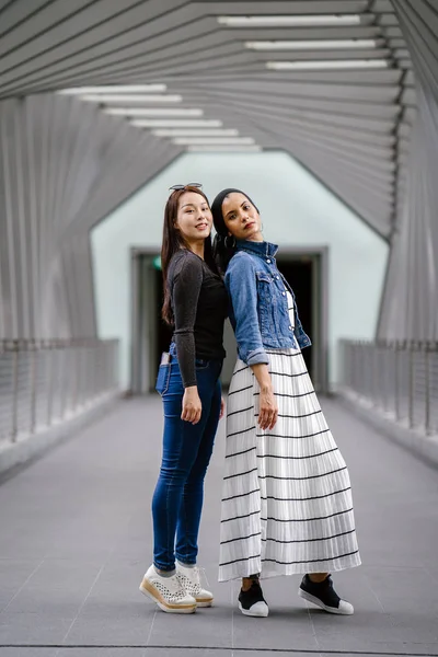 Gündüz vakti köprüde farklı etnik kökenlere sahip iki arkadaş. Biri Malezyalı Müslüman bir kadın, diğeri de Çinli bir Asyalı. İkisi de genç, enerjik ve çekici..