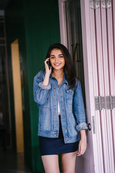 Onun Smartphone'da bahseden bir güzel, uzun boylu, zarif ve genç Hintli Asyalı kadın portresi. O bir retro Kot ceket giyiyor 