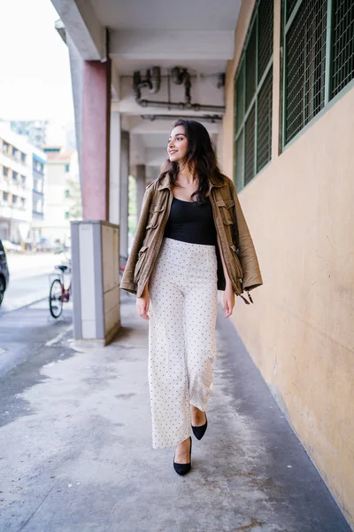 Gün boyunca bir geçit Asya'da bir şehirde yürürken bir uzun boylu, güzel, ince ve zarif Hint Asyalı kadın portresi. O zarif giyindi ve bir ceket omuzları üzerinde bol dökümlü vardır.