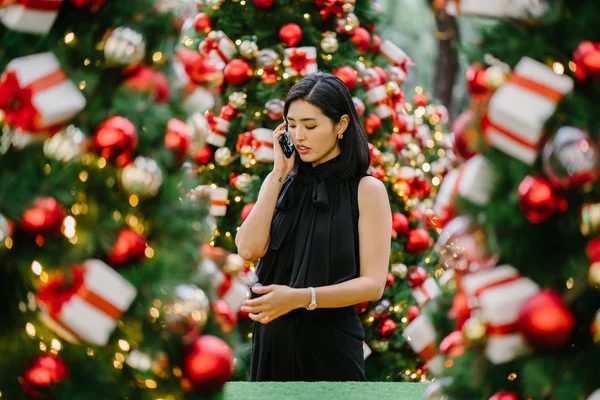 O tutar kadar bir akıllı telefon olarak gülümseyen bir genç, çekici ve fotojenik Kore Asyalı kadın portresi