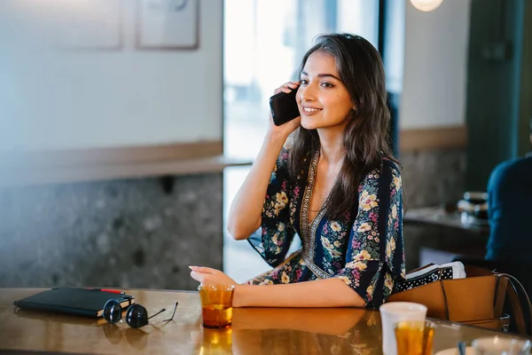 Bir kafede onu smartphone o görüşmeler olarak gündüzleri çatık bir genç ve çekici Hint Asyalı kadın portresi