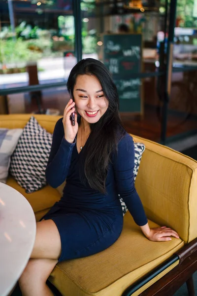 一个年轻貌美的亚裔中国女人用智能手机说话的画像 — 图库照片